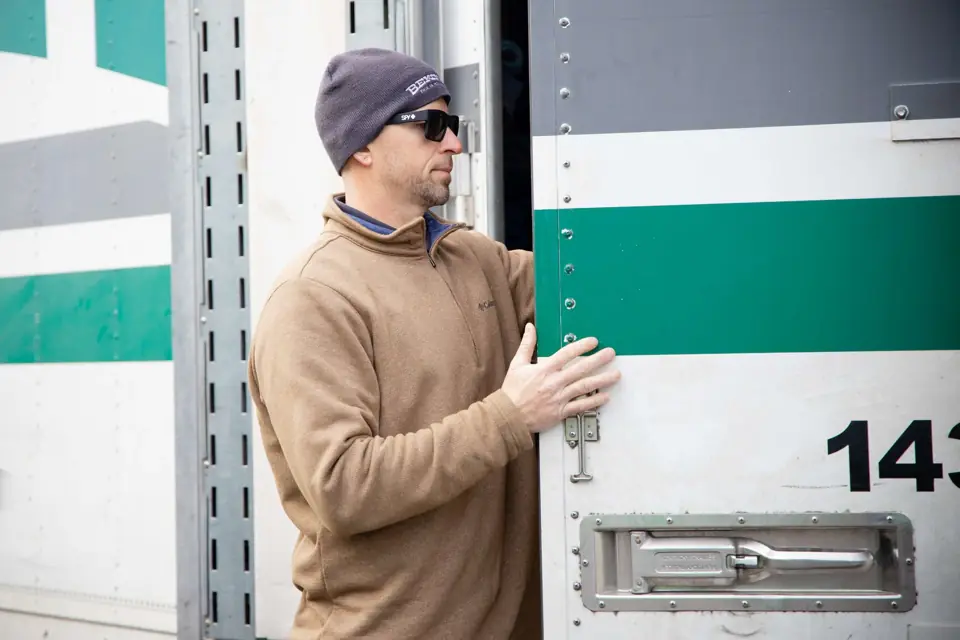 An O'Brien's mover closing the door of a trailer with the green Bekins stripe
