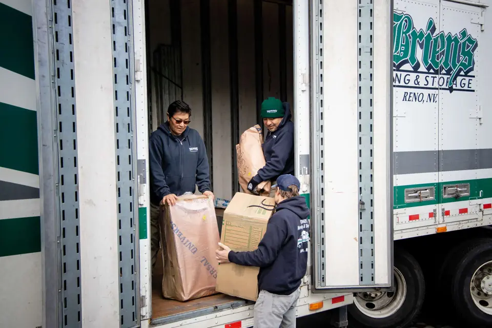 O'Brien's movers unloading cartons at the trailer doors, the O'Brien's lettering on the trailer