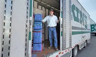 An O'Brien's mover standing in the side door of a Bekins trailer