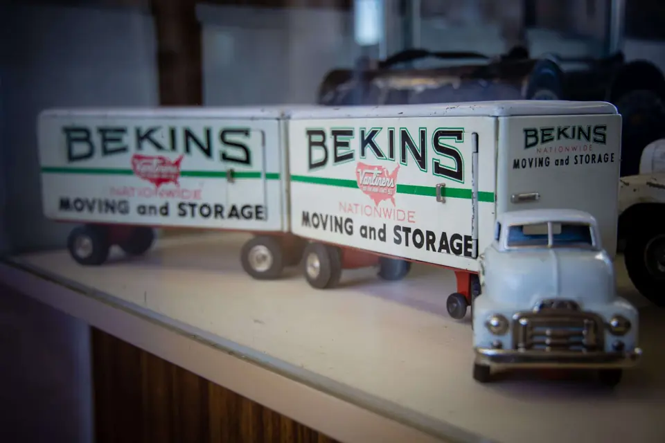 Vintage Bekins Moving and Storage toy trucks on a shelf
