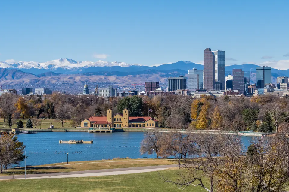 Denver skyline across City Park lake with the snow-capped Rocky Mountains behind