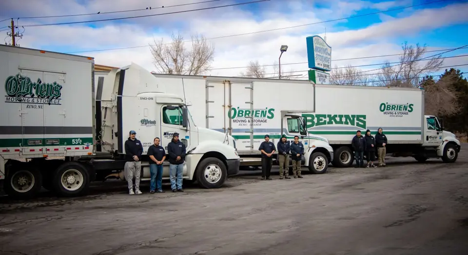 Three O'Brien's and Bekins trucks parked in a row in the yard