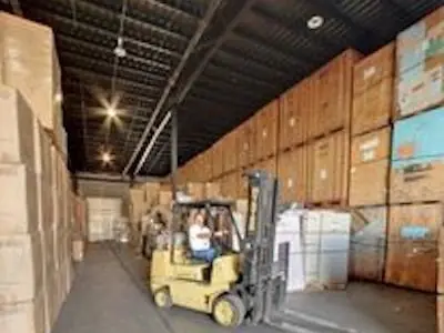 A forklift between stacks of storage vaults in the O'Brien's warehouse